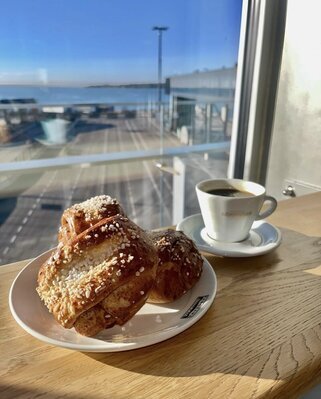 Kahvitauko ennen matkalle lähtöä! <b>Kahvitauko ennen matkalle lähtöä!</b><br>Pysähdy nauttimaan tuoreesta kahvista ja pullasta ennen laivalle lähtöä.